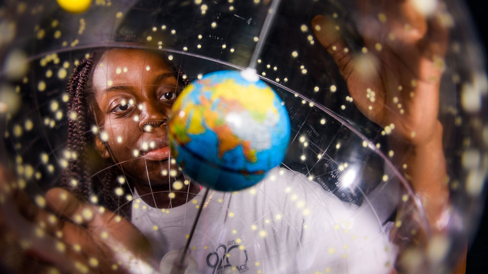 A student looking at a globe